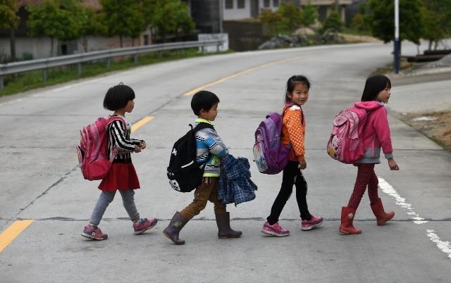 4月27日,放学后小彭(右一)和同学们一同排队过马路