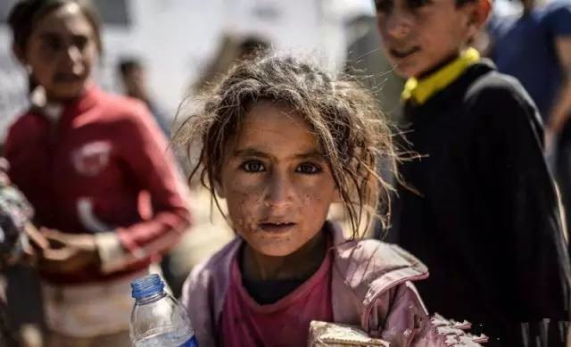 叙利亚的难民爸爸饥饿难耐,找到了一小块馕饼,对孩子说:我闭上眼你再
